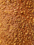 Brotkruste mit knusprigen Kartoffelstücken als Topping, Nahaufnahme