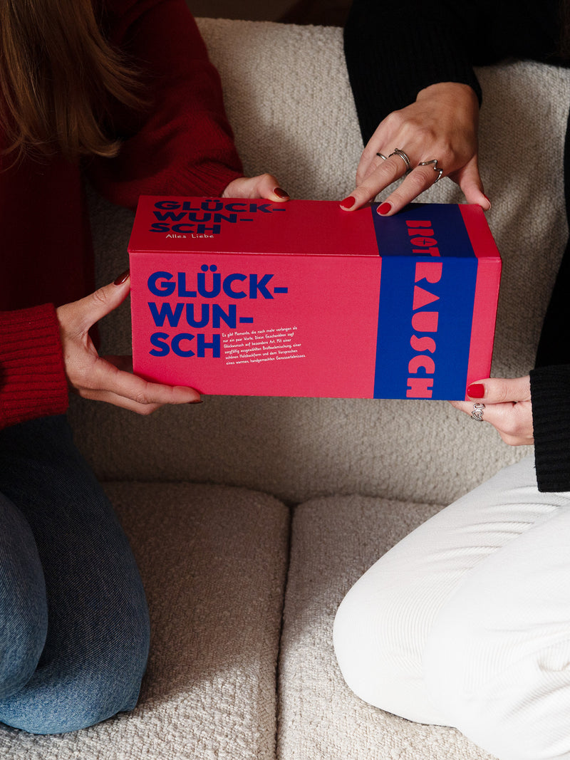 Hände halten eine Glückwunsch Geschenkbox von Brotrausch als Geschenk zum Geburtstag