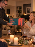 Mann überreicht beim Weihnachtsessen eine Brotrausch Geschenkbox mit Brot zum Selberbacken